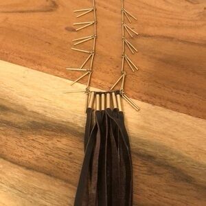 Long gold necklace with leather tassel